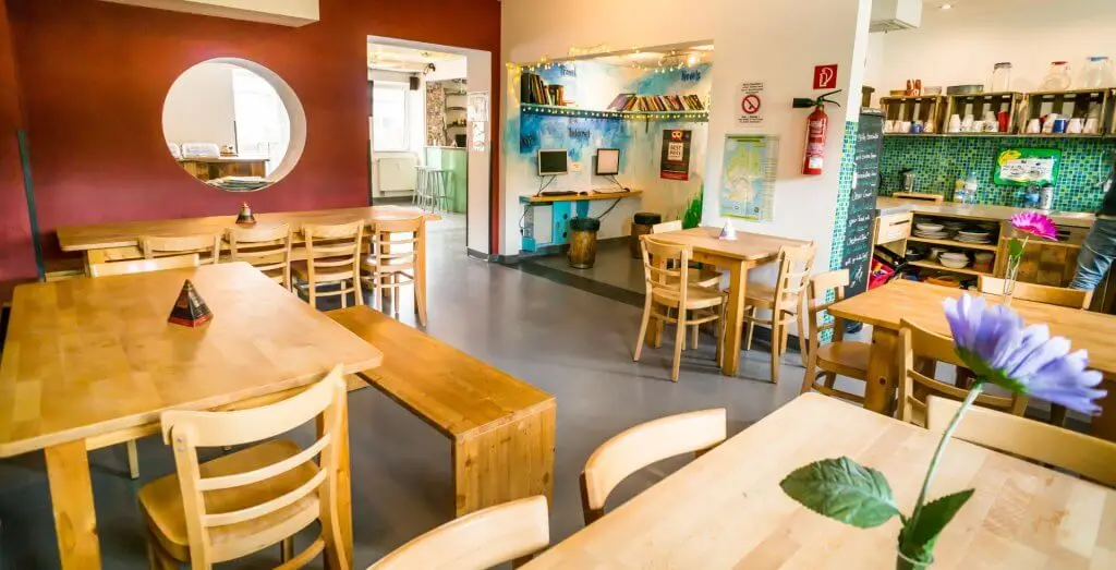 Aufenthaltsraum im Babelfish-Hostel mit mehreren Tischen und Sitzmöglichkeiten