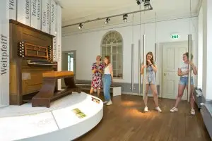 vier Frauen schauen sich ein Klavier und mehrere Klangröhren im Bachmuseum in Leipzig an
