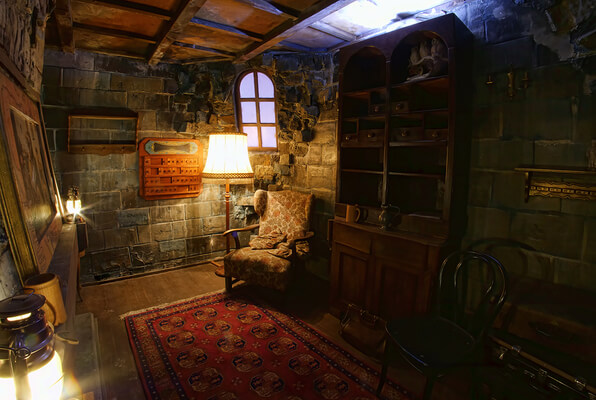 Ein Escape-Room, eingerichtet als alte Bibliothek mit Stehlampe, Bücherregal, Gemälden und Teppich