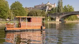 Hausboot auf dem Main vor der Kulisse der Löwenbrücke und der Festung Marienberg