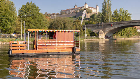 Hausboot auf dem Main vor der Kulisse der Löwenbrücke und der Festung Marienberg