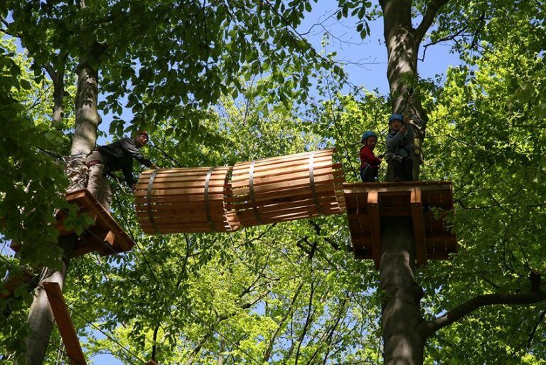 2 Kinder auf einer Plattform in den Bäumen im Kletterwald Mannheim