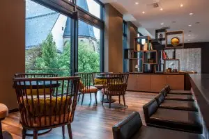 Lobby des Motel One Leipzig mit mehreren Sitzgruppen in gedimmten Ambiente