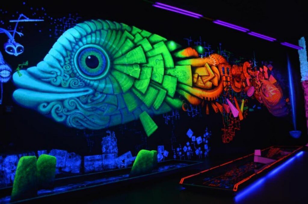 großes ultraviolett-leuchtendes Gemälde eines Fisches an der Wand