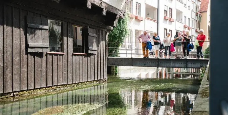 Gruppe von Touristen bei einer Stadtführung auf einer der vielen kleinen Brücken im Ulm