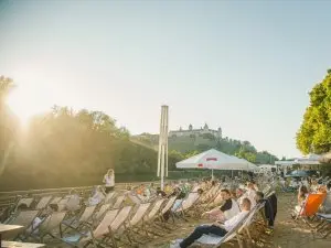 Stadtstand Würzburg mit Liegestühlen, Sonnenschirmen und Blick auf den Main und die Festung in Würzburg