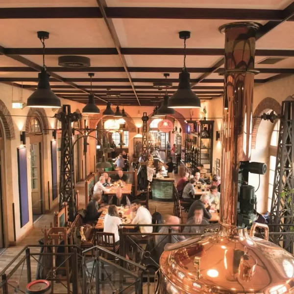 Blick auf den Gastraum im alten Bahnhof Leizpig mit großem kupfernen Braukessel