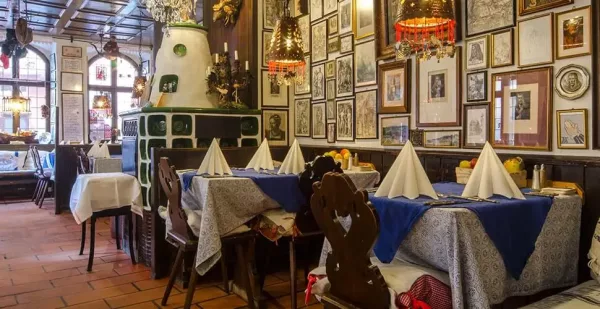 Innenansicht des Gastraums der Albrecht Dürer Stube mit Kachelofen und Gemälden und Bildern an den Wänden