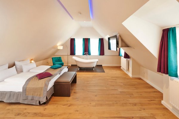 Doppelzimmer im Dach im Hotel Elch mit großem Doppelbett und freistehender Badewanne