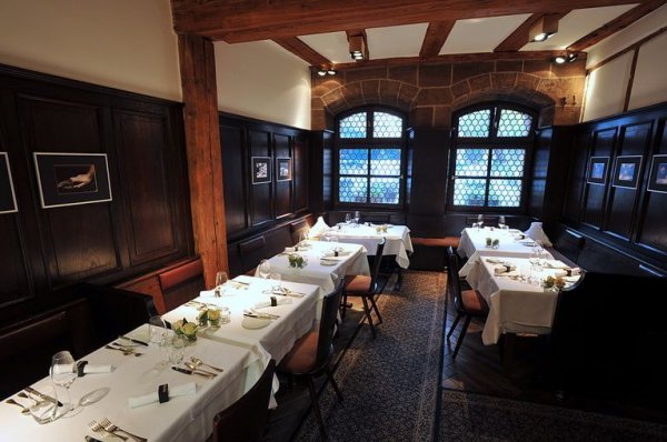 Gastraum des Restaurants Essigbrätlein mit schwarzer Holzvertäfelung und Fachwerk