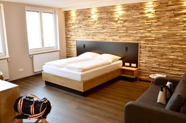 Doppelzimmer im Five Hotel mit Couch und Wandpanelen aus Holz