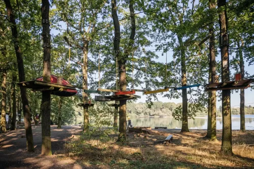 eine der vielen Kletterstationen im Kletterwald Leipzig mit Blick auf den See