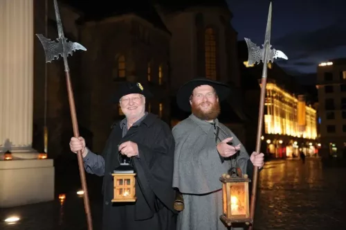 zwei als Nachtwächter verkleideter Männer posieren mit ihren Hellebarden und Laternen