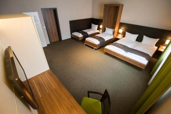 Blick in ein 4er Zimmer im Hotel Riku mit einem Doppel- und zwei Einzelbetten